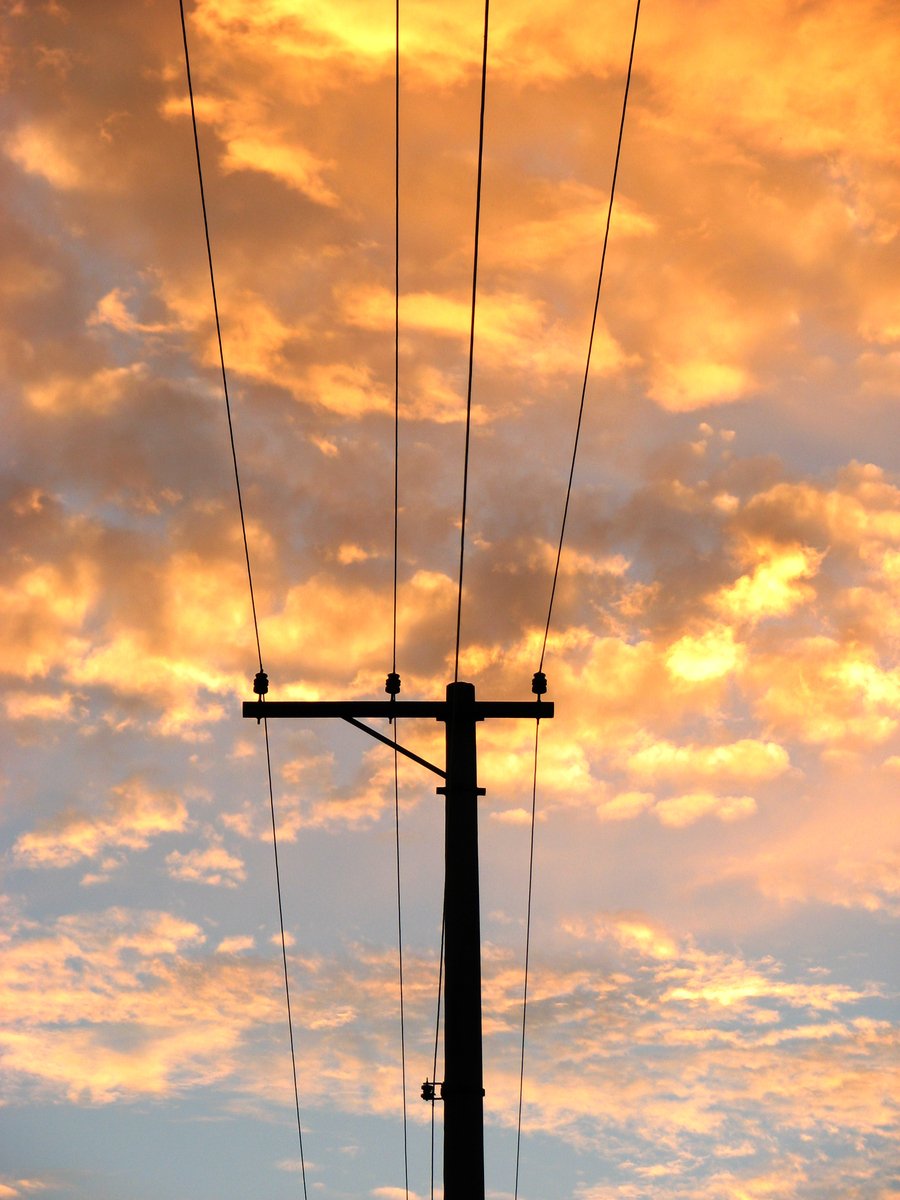 telephone pole with wires under a colorful sky