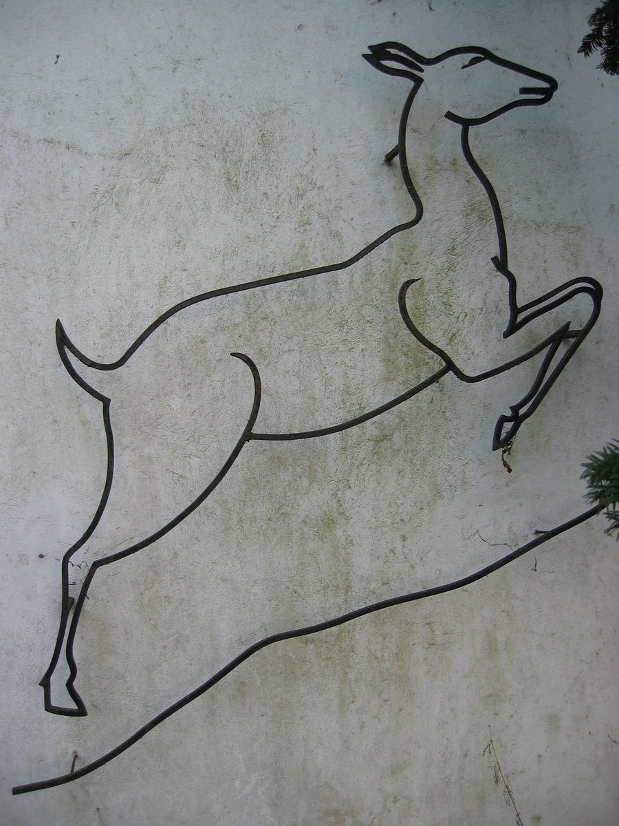 an artistic image of a deer leaping over a wall