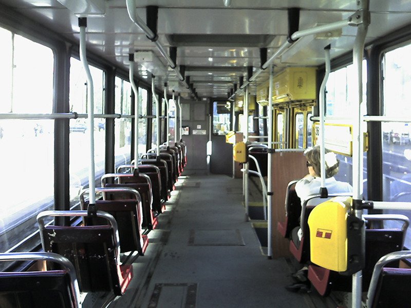 the inside of an empty bus with people on it