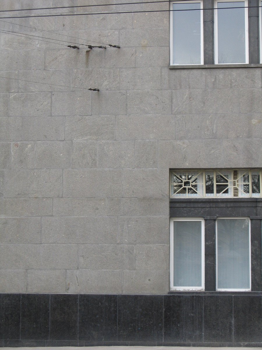 the exterior of an apartment building with broken windows