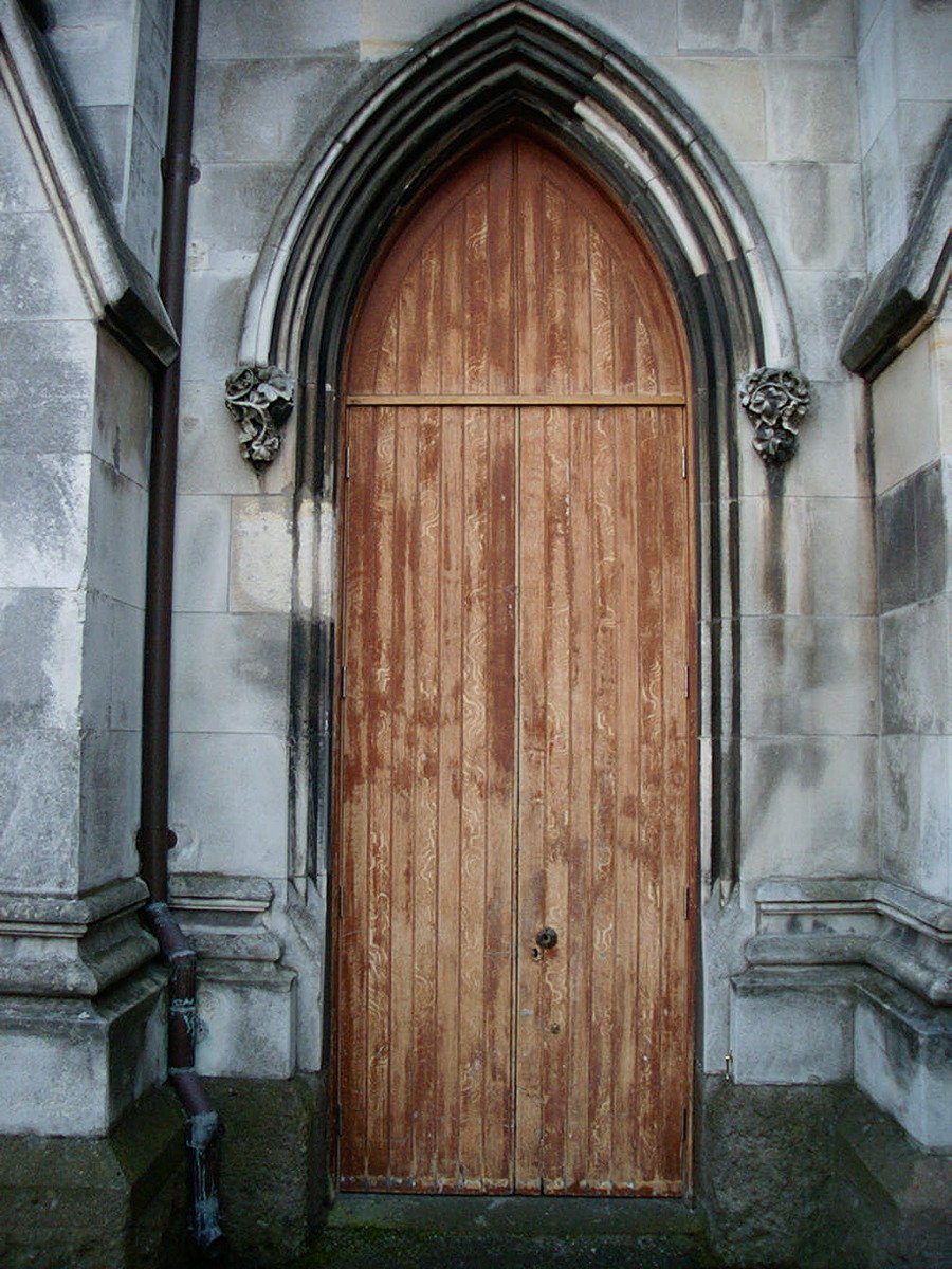 a wooden door sitting in front of an arch