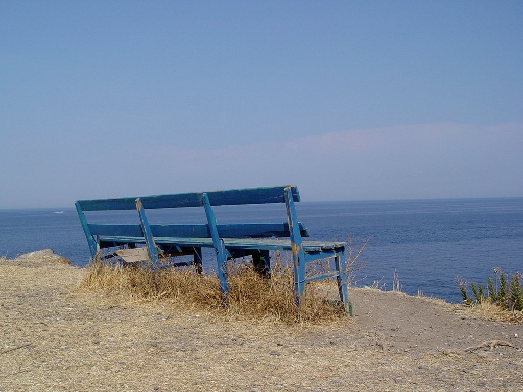 a lonely bench on the edge of a cliff overlooking the ocean