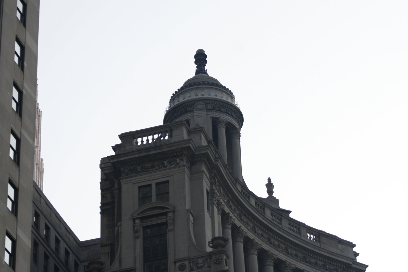 a very tall grey building with a sky background