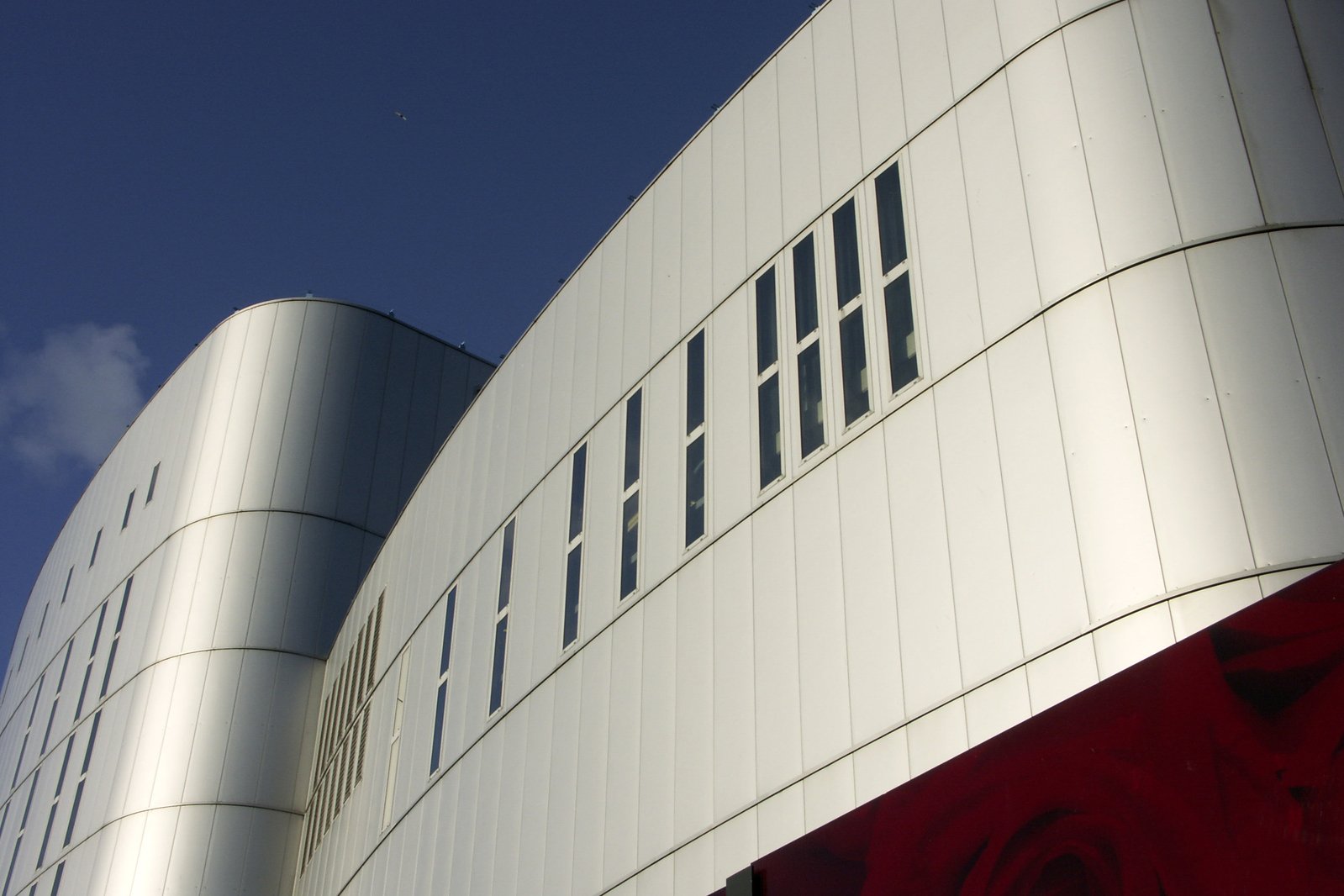 two large metal and glass buildings in front of the sky