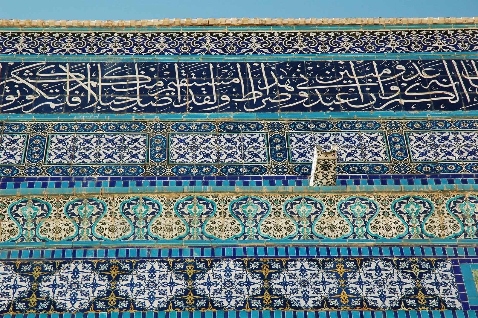 an intricately decorated wall with arabic calligraphy