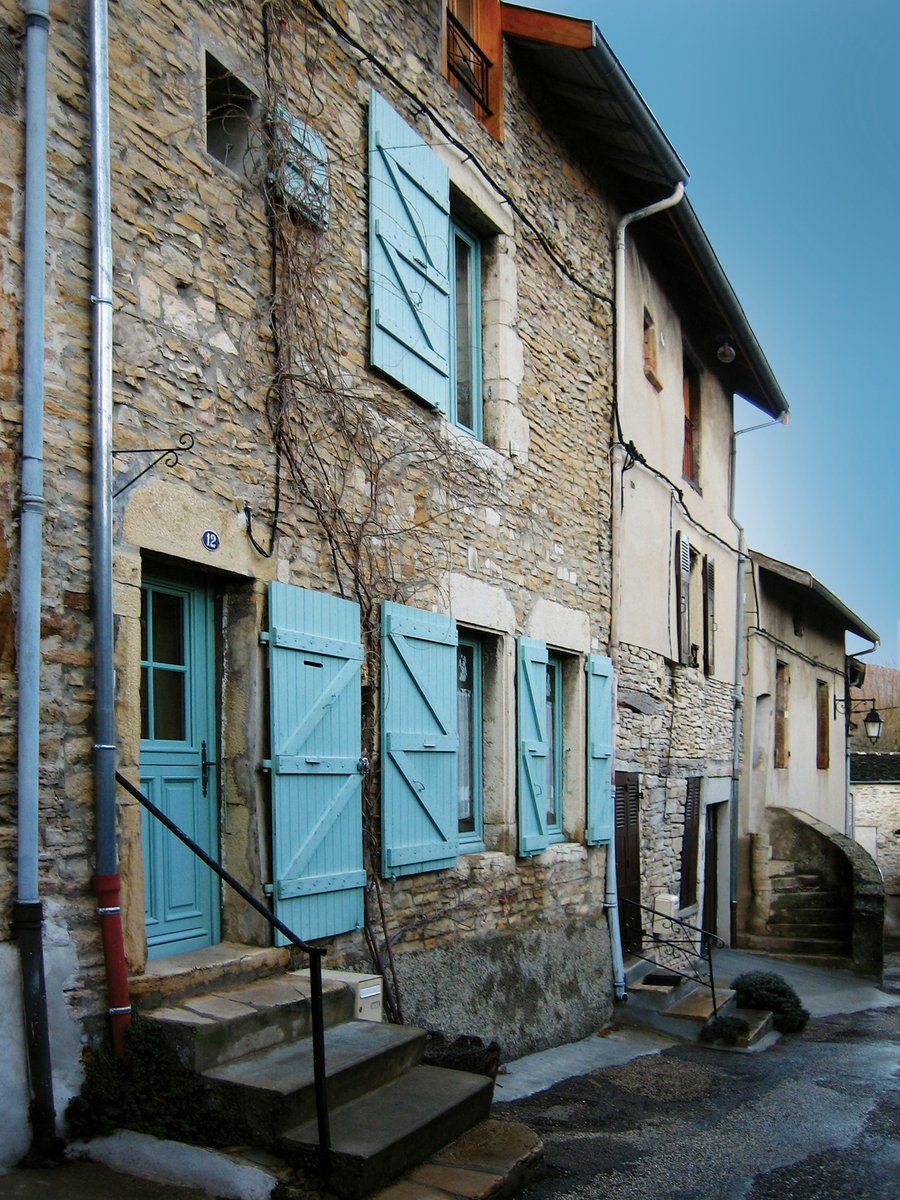 blue shutters are open on a brown brick house