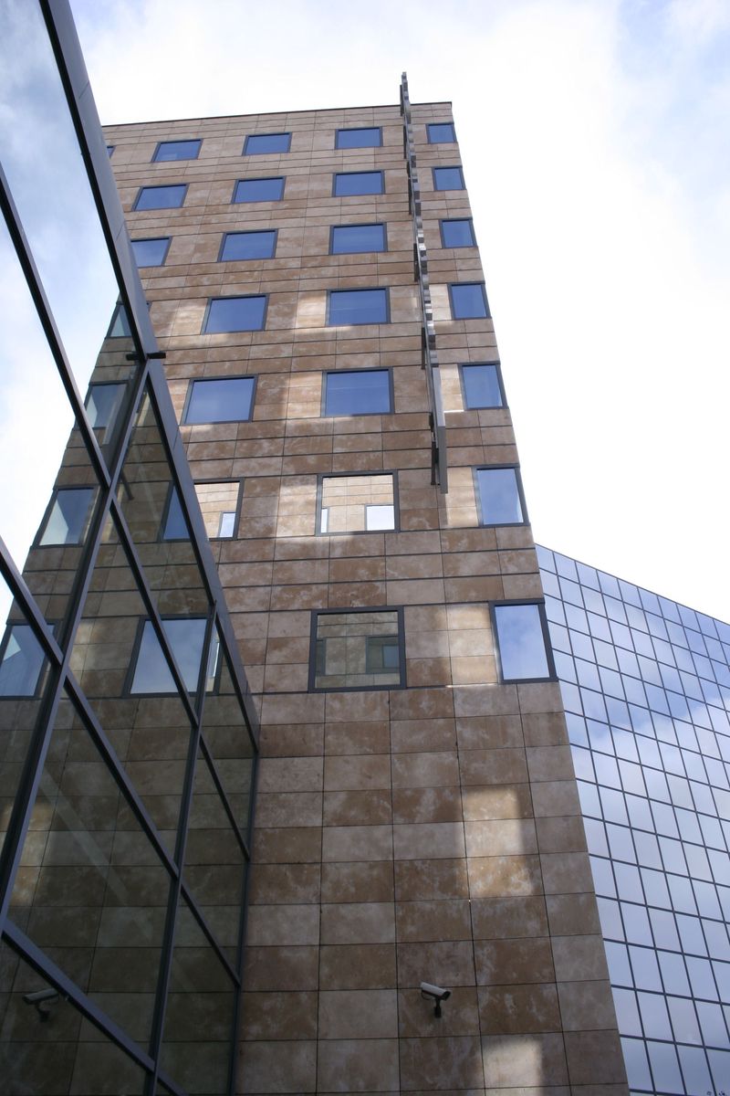 a window on the side of a building reflecting the sky