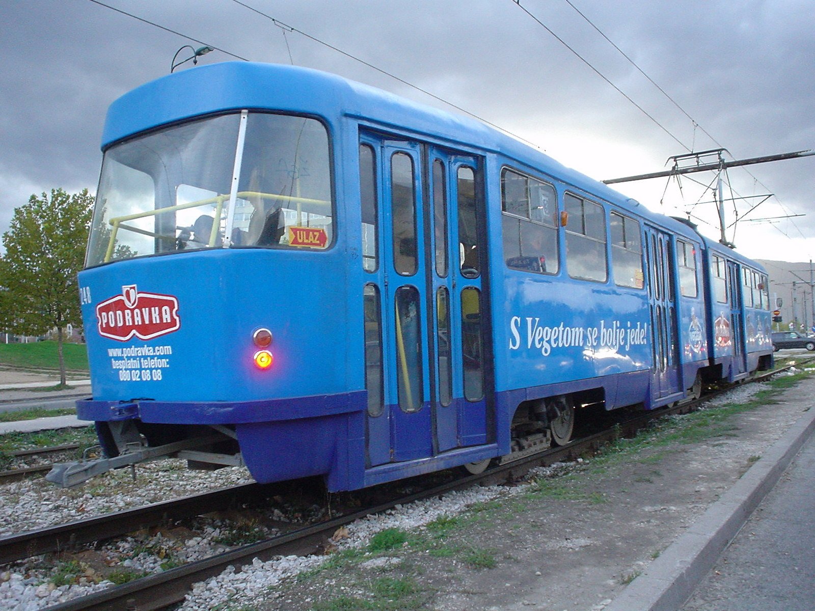 a blue trolley car on some train tracks