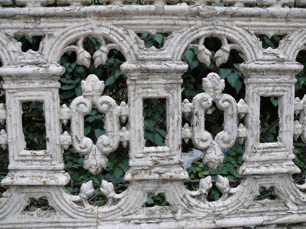 an ornate carved out design with leaves growing from it