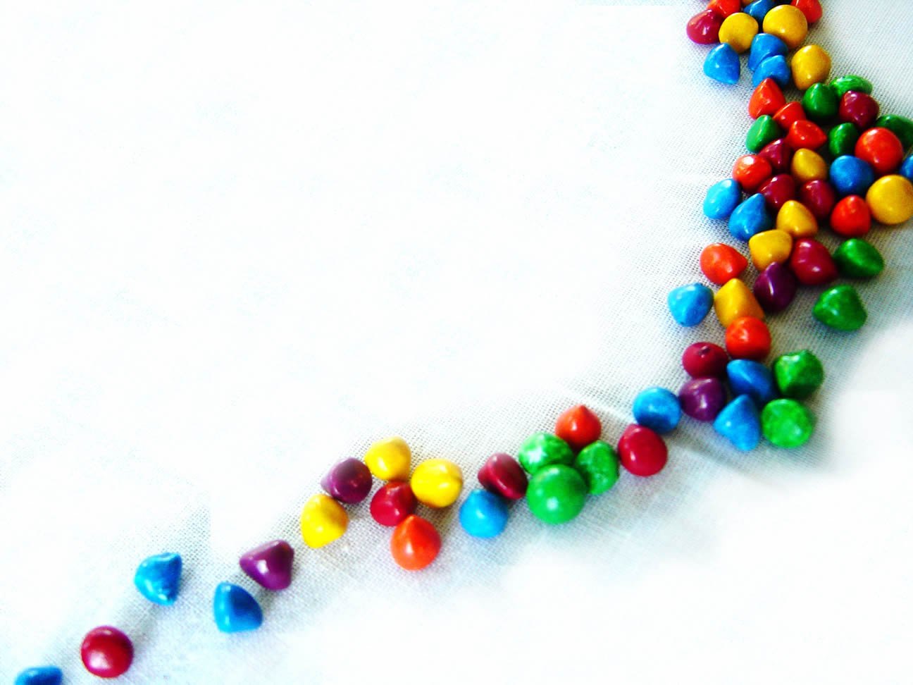 a line of candy beans laying on top of a white surface
