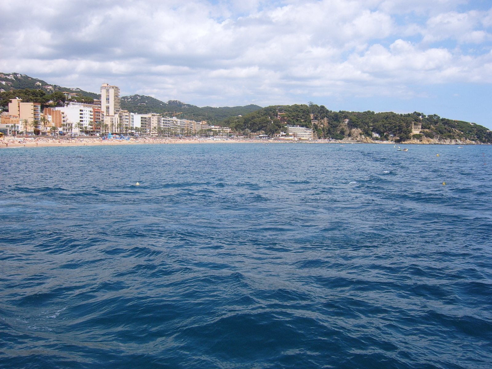 a view of some buildings and a beach in the water