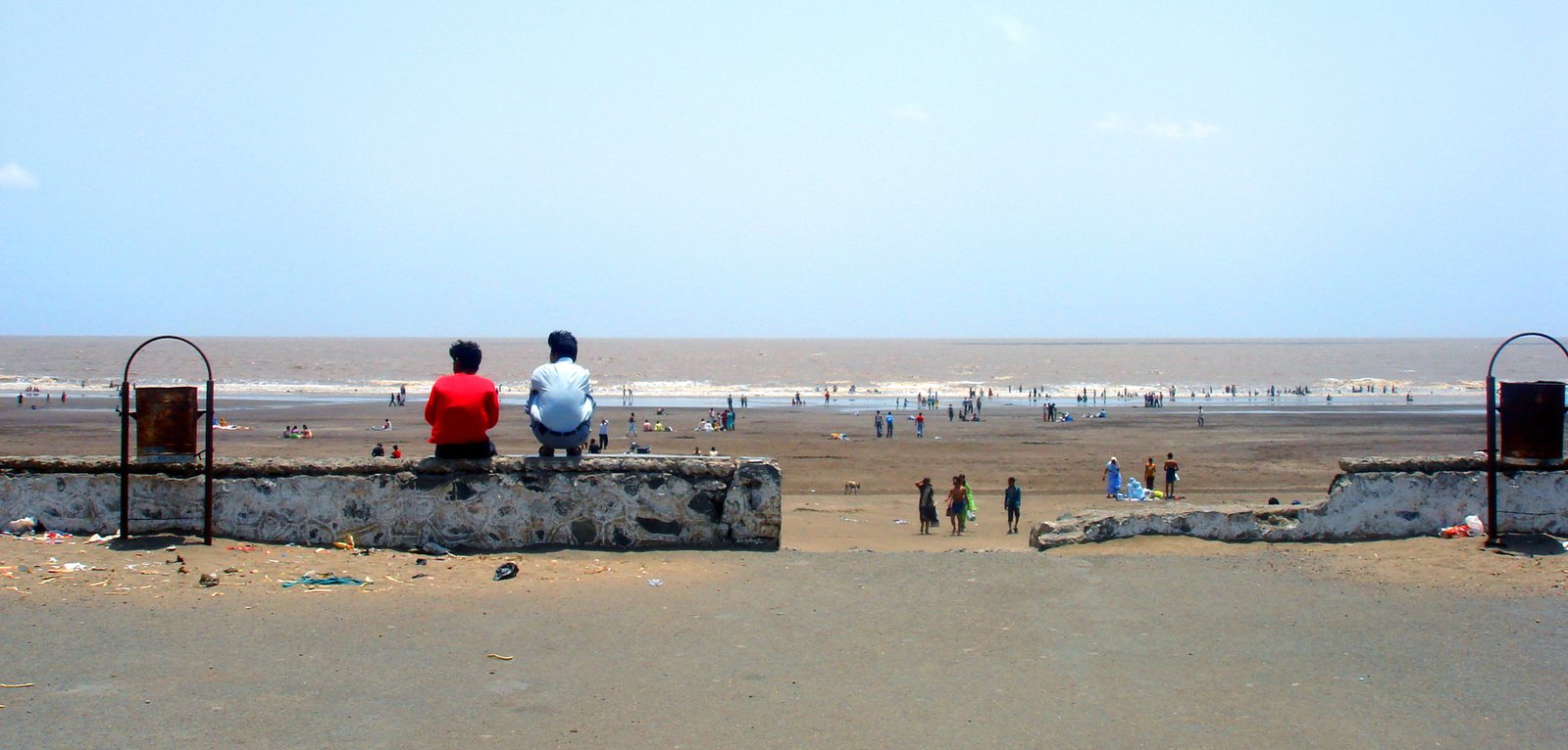 some people standing on a wall with a blue sky