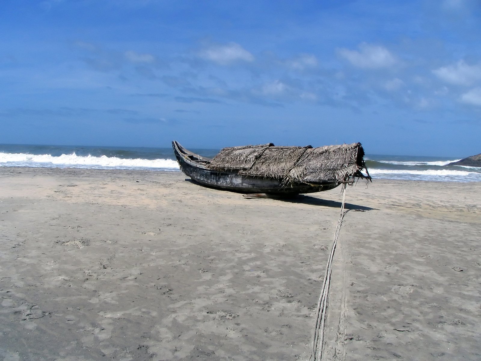 a boat is on the beach in front of the ocean