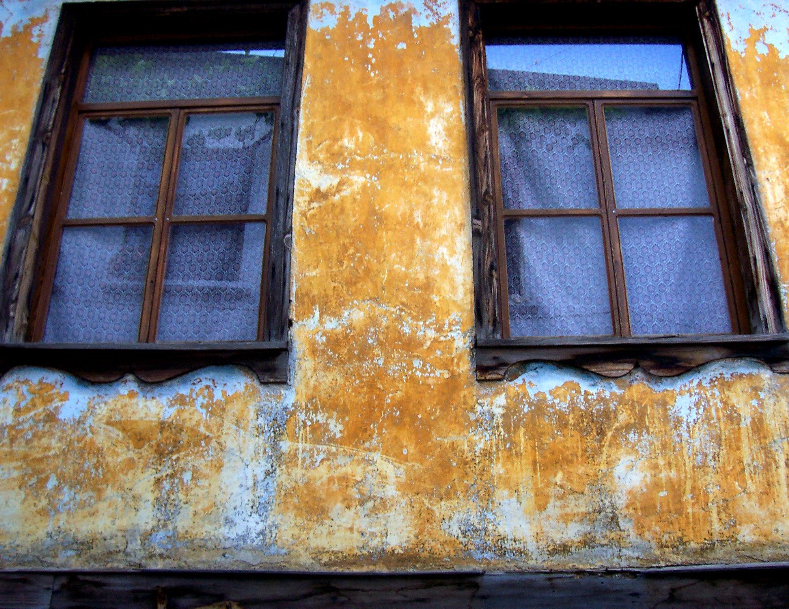 a yellow building that has two windows