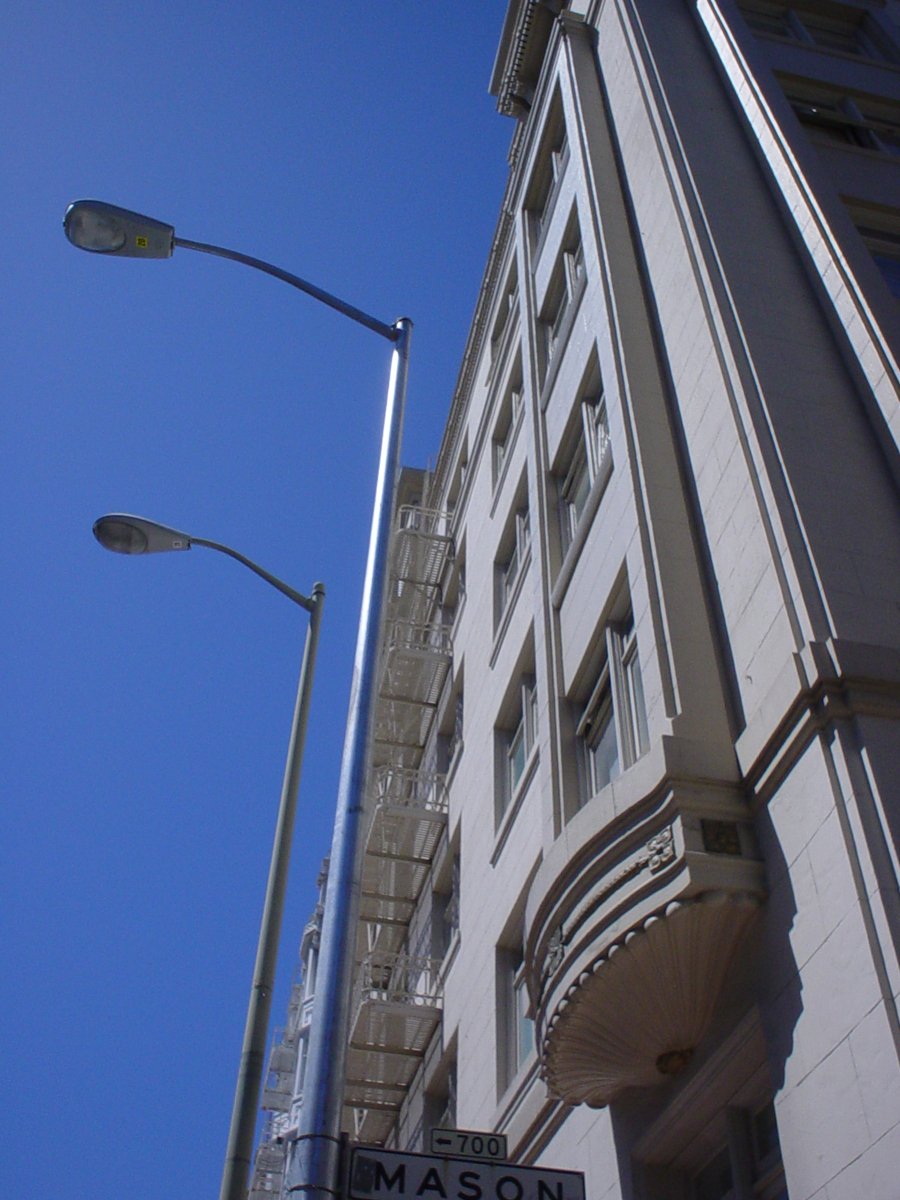 street lamp on the corner of a very tall building