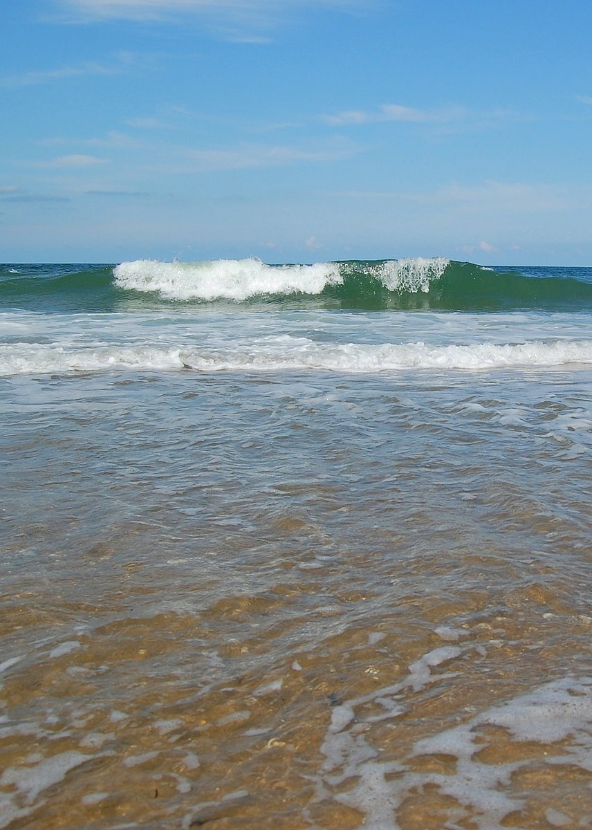 the wave is rolling in towards the beach