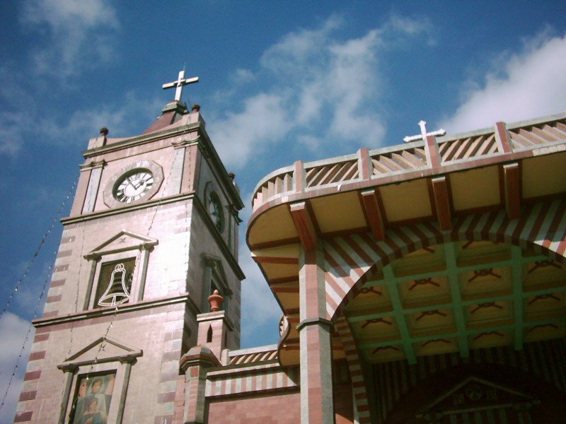 a cross is above a church steeple with an arched doorway