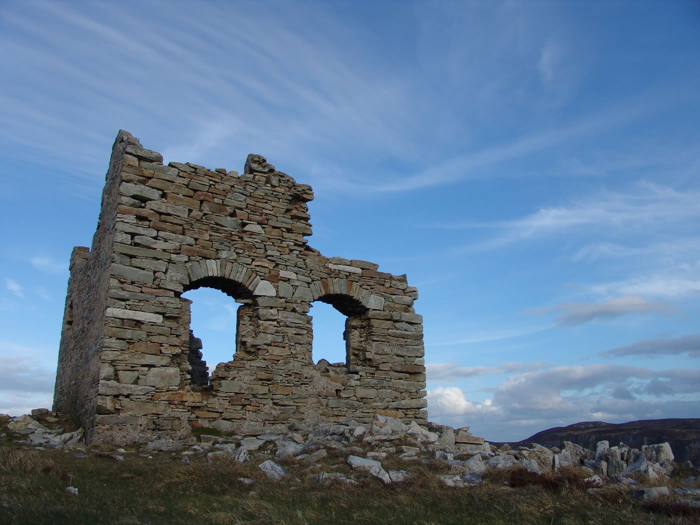 a rocky structure with an arched window in the side of it