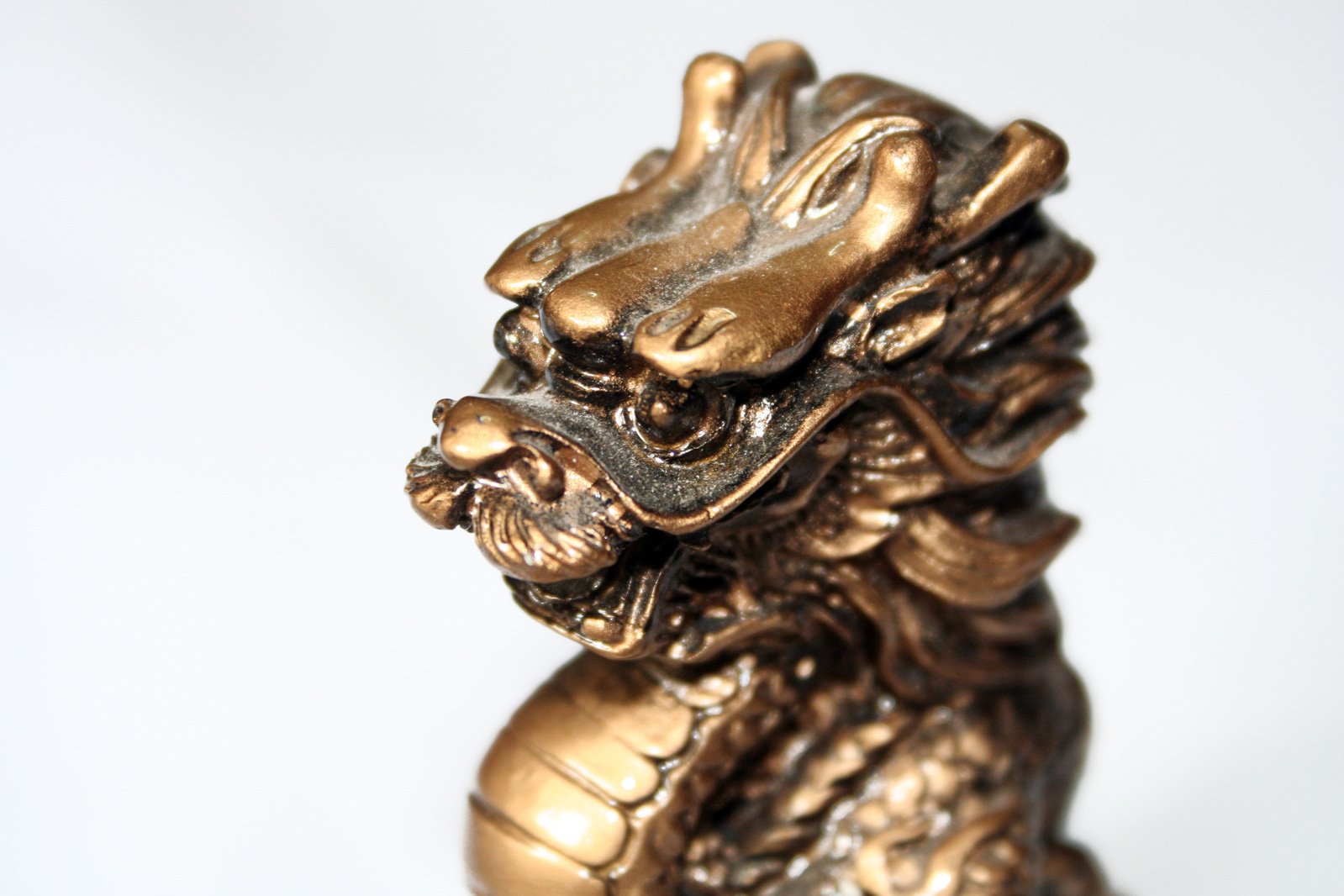 a gold colored oriental sculpture of a lion