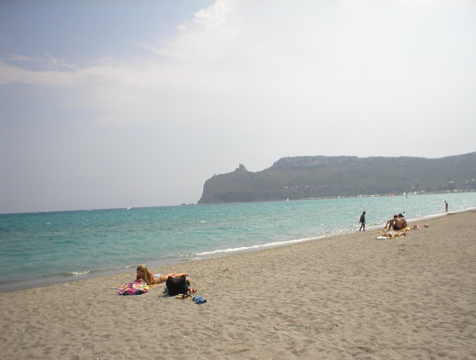 a couple of people sitting in the sun on a beach