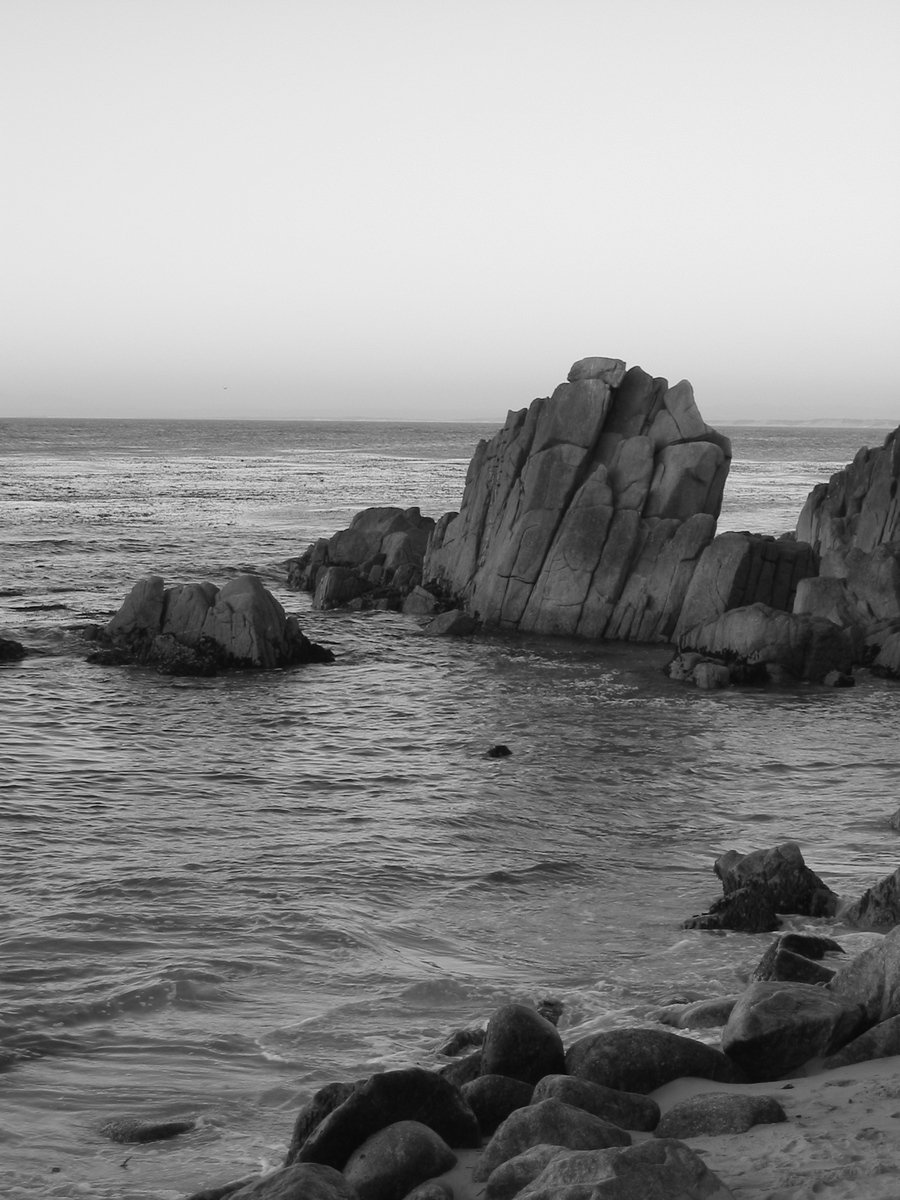 a couple of rocks sitting on top of a beach