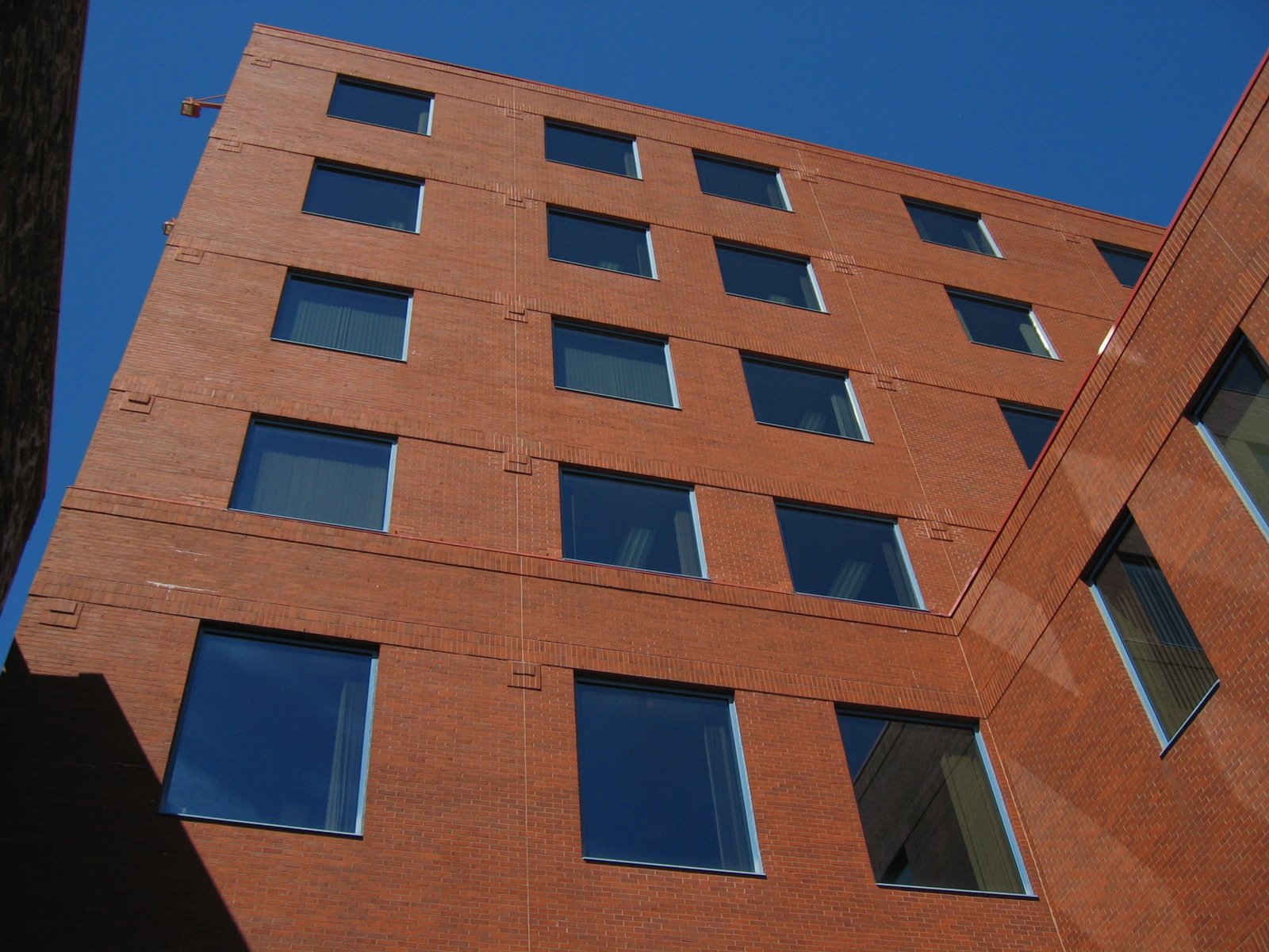 a tall brick building has windows and blue sky