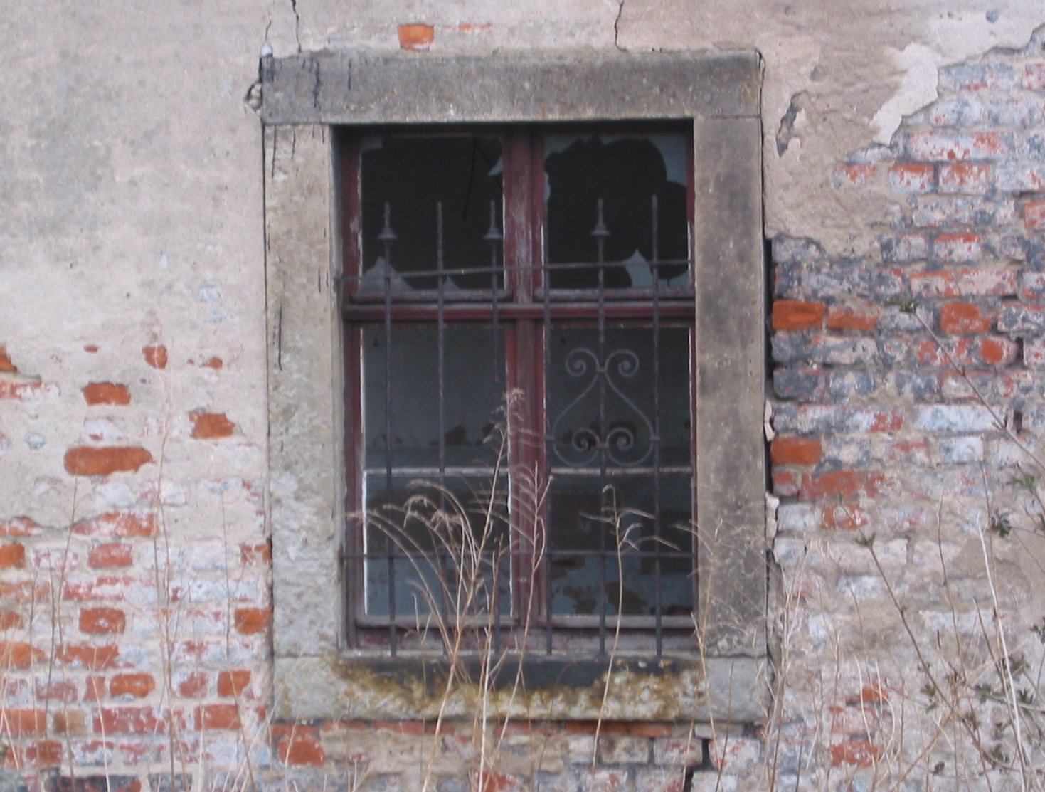the windows of an old building have a barred window