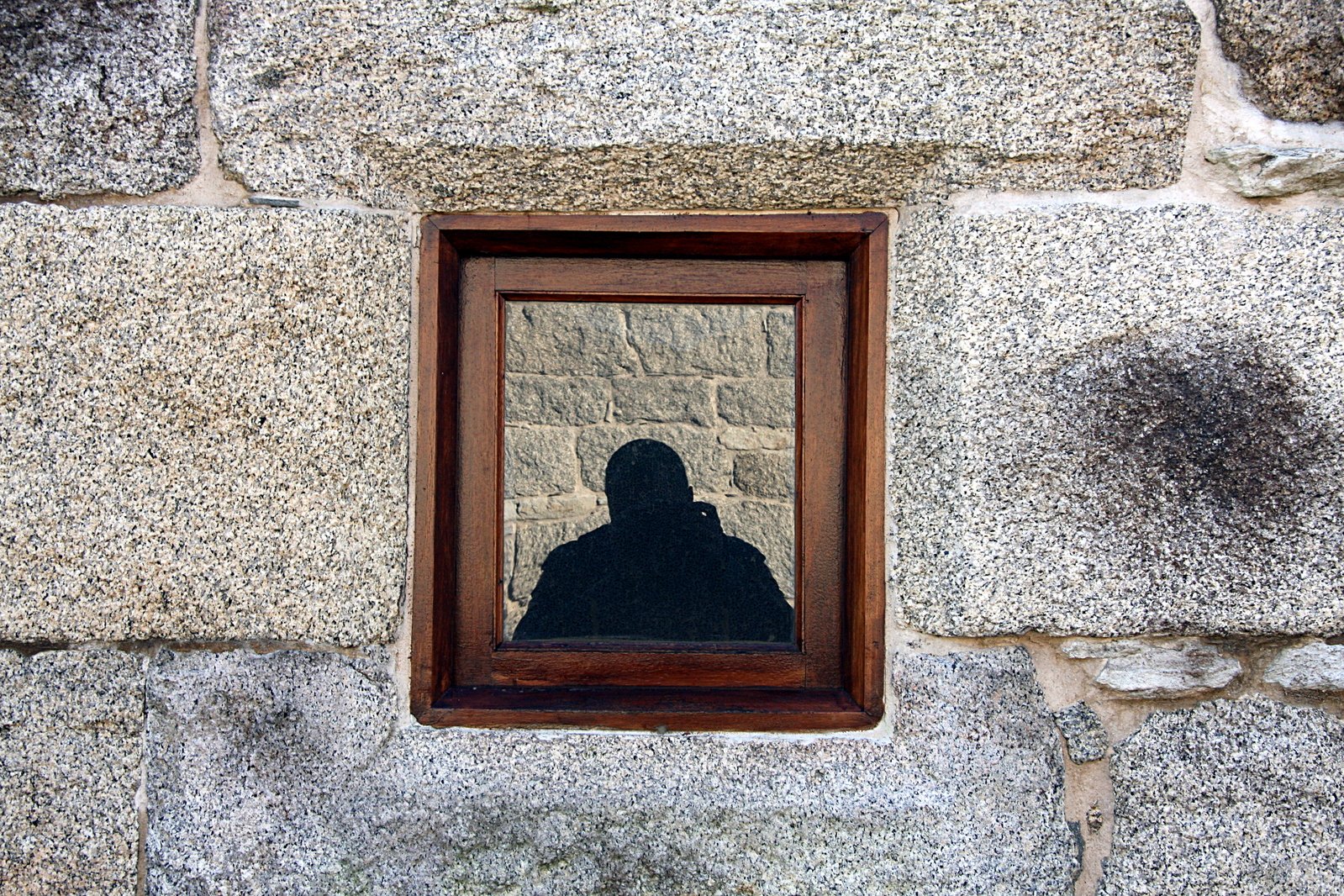 a reflection of someone sitting in a window