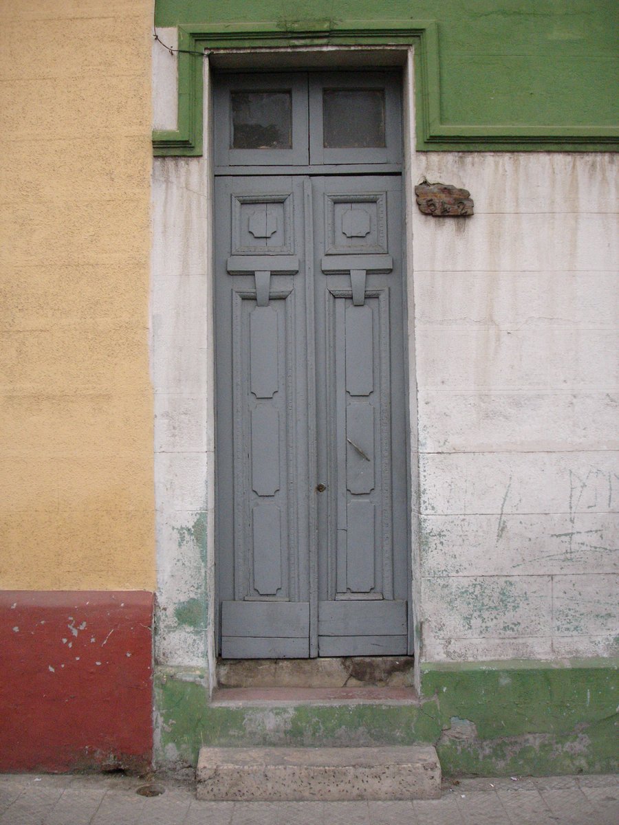 a blue door in front of a yellow building