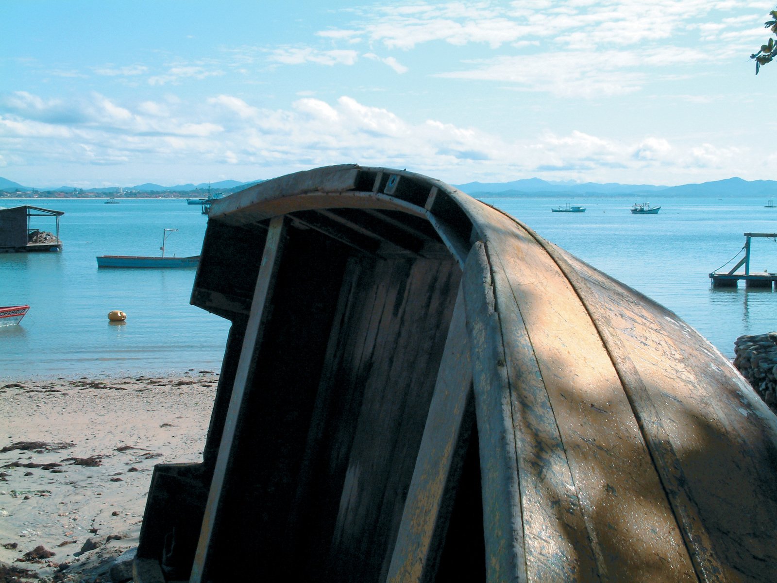 a large boat sitting on top of a beach next to the ocean