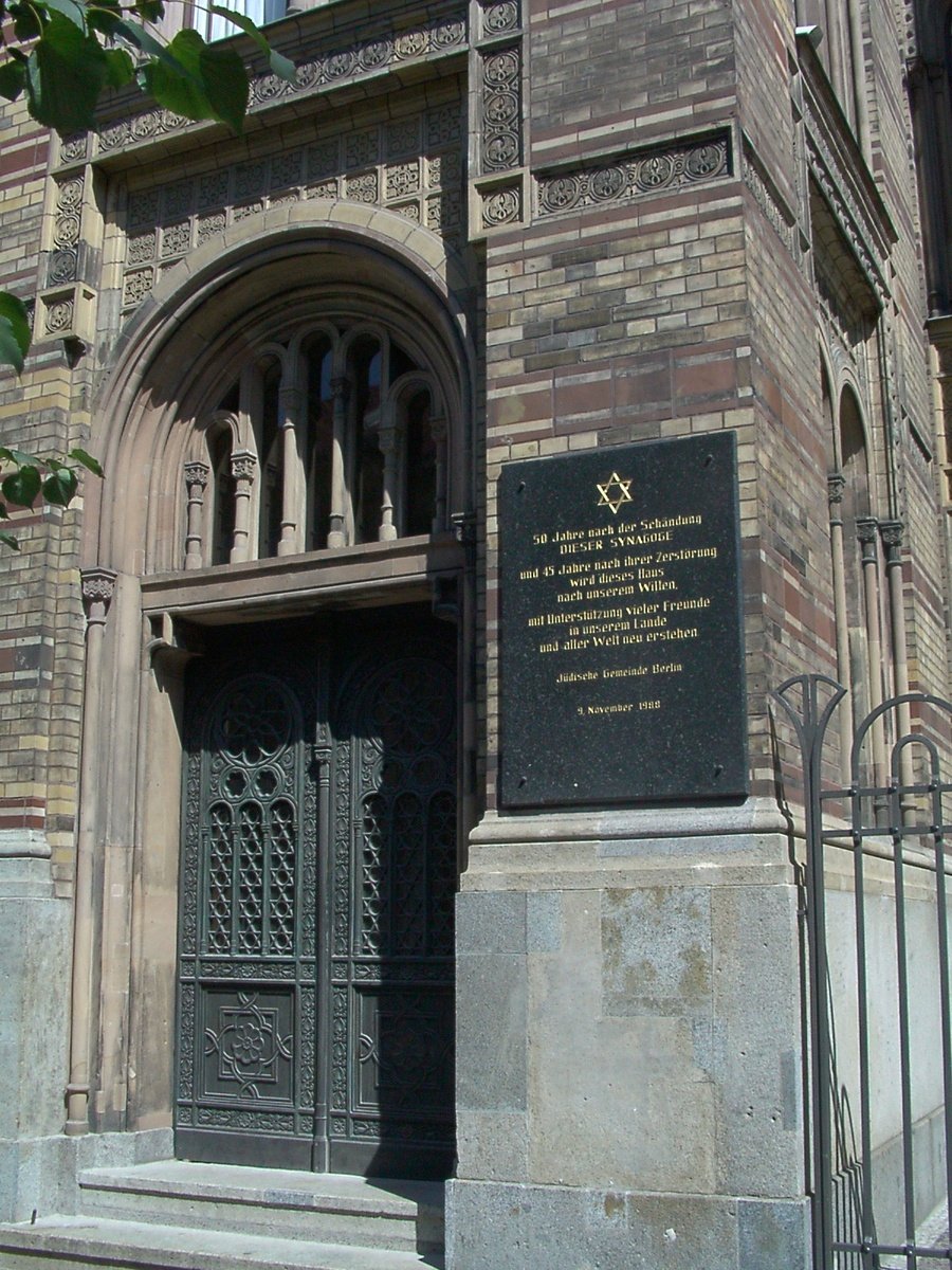 a tall building with an iron gate and writing on the wall