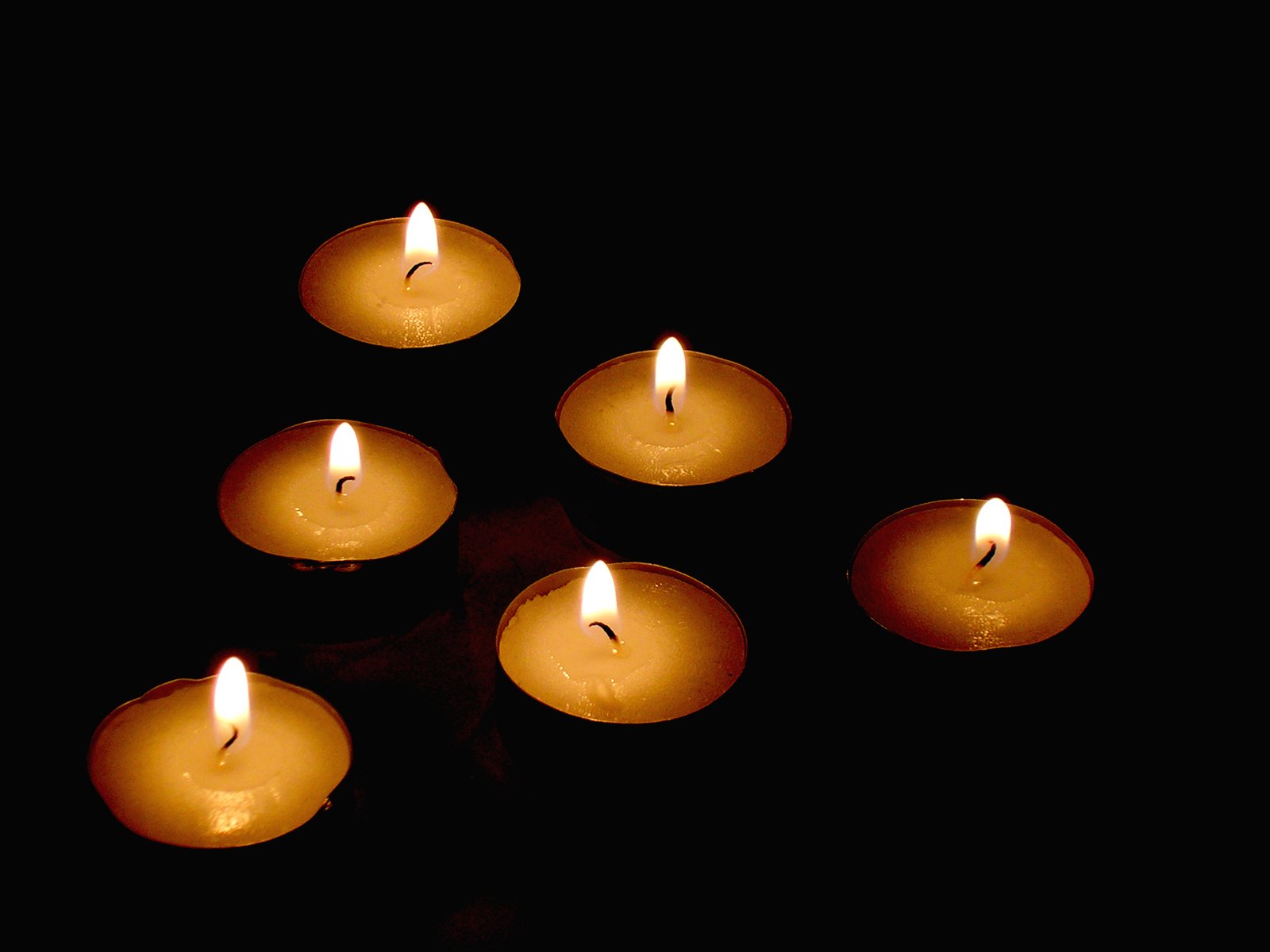 several lit candles on a table lit up