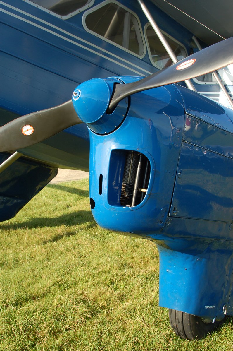 the propeller and wings of an airplane sitting on a grassy area