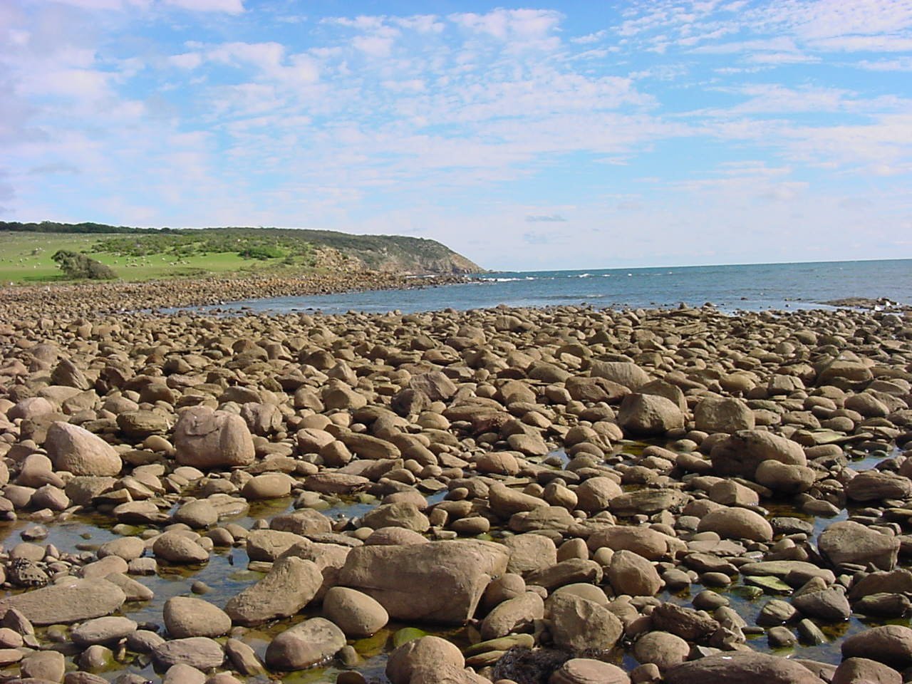 rocky shoreline with small rocks on the water