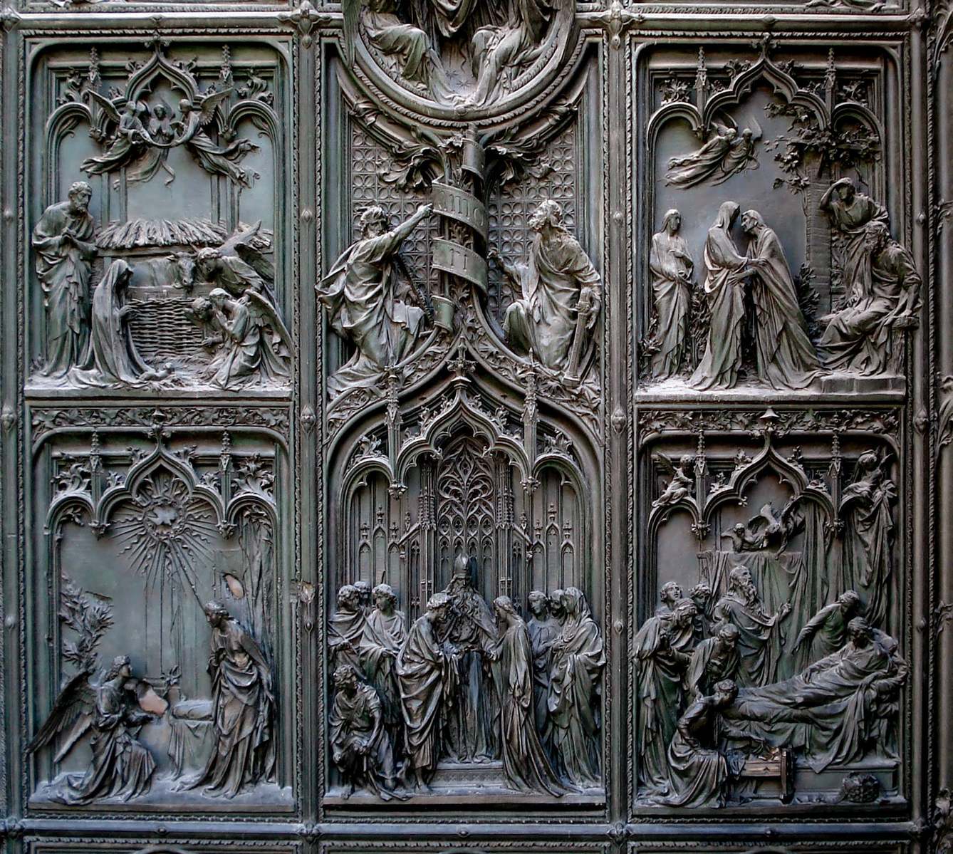 carved metal panels with people around them on a building