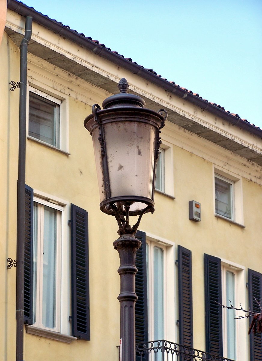 a light pole and window ledge outside a yellow building