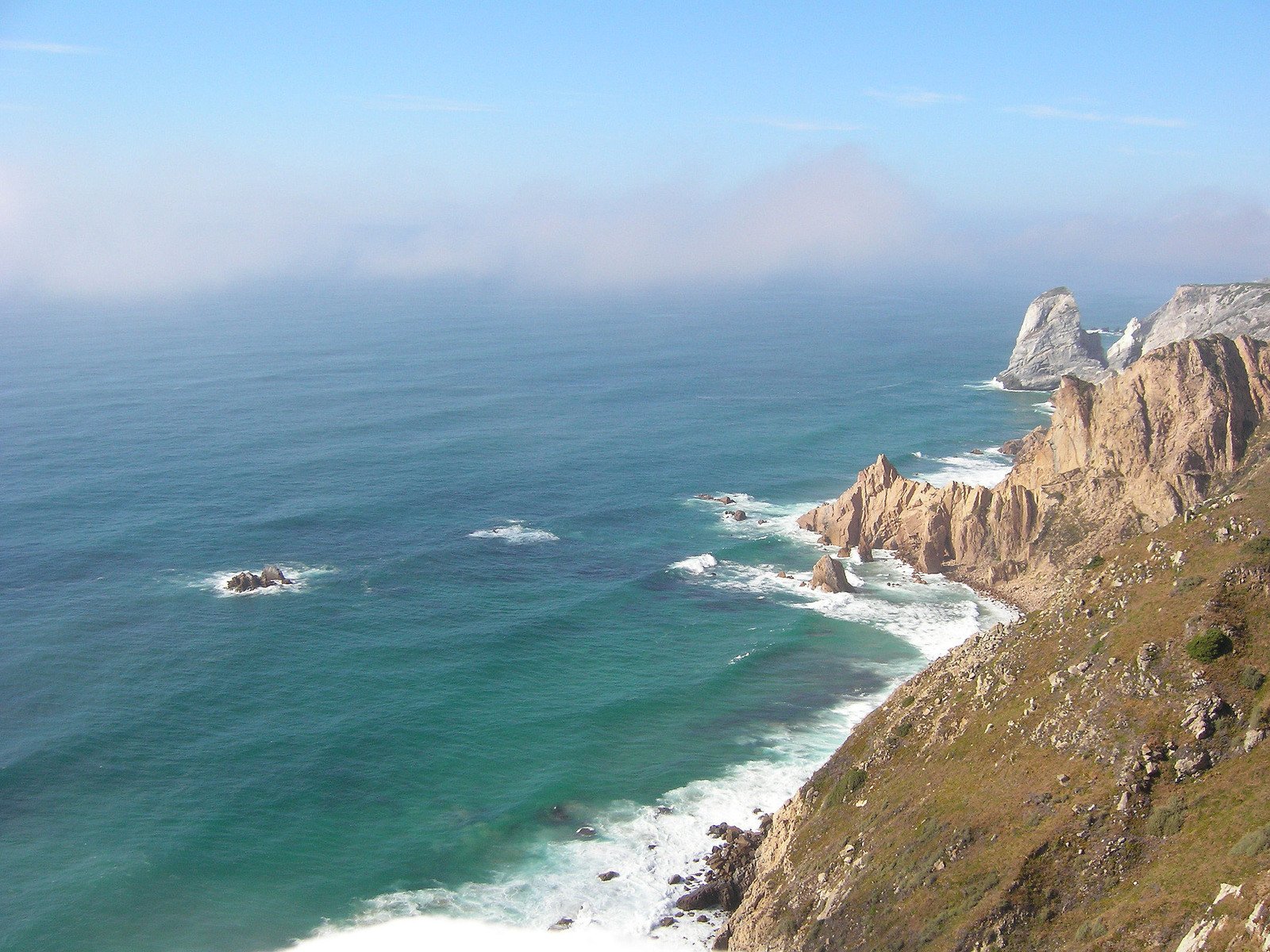 the rocky coastline and blue ocean line the horizon