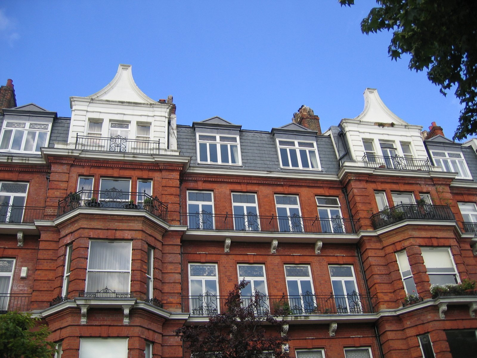 a large red brick building with many windows and balconies