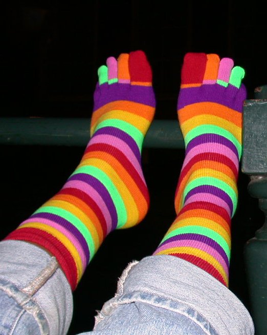 someones feet and socks are multi colored