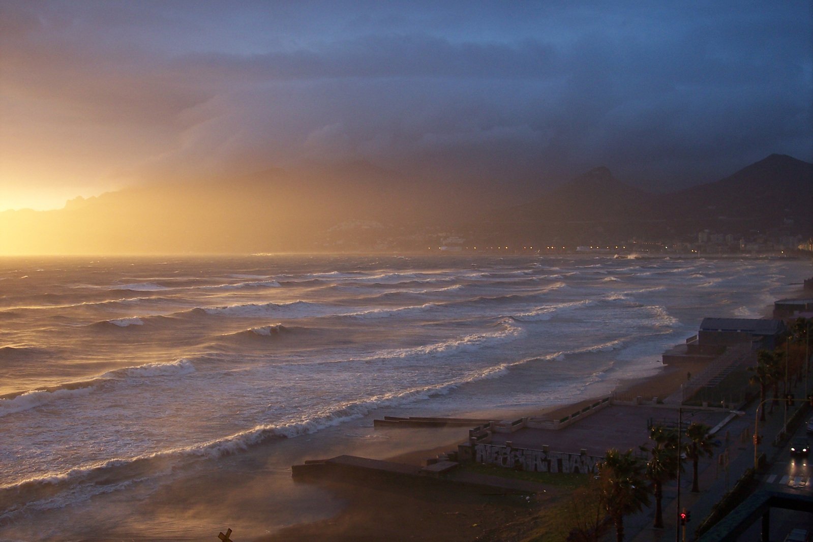 waves on the shore in front of a setting sun