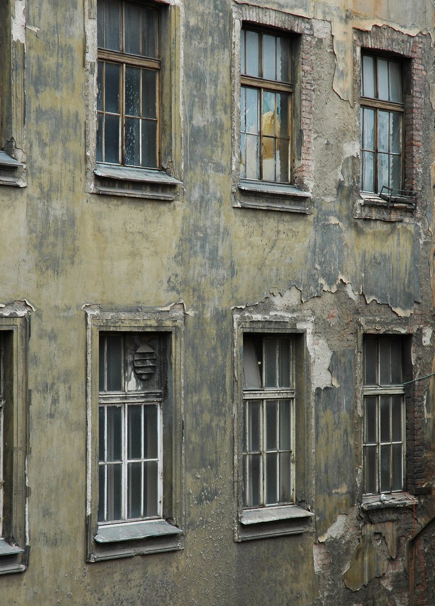 several windows on the side of an old building