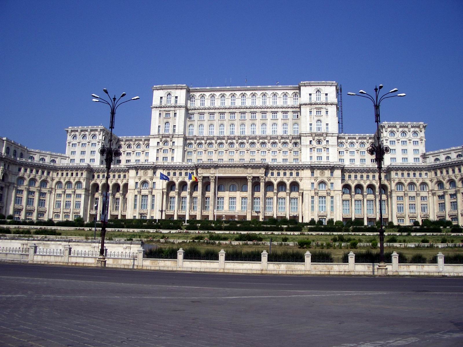 a very large building is shown here with two street lamps