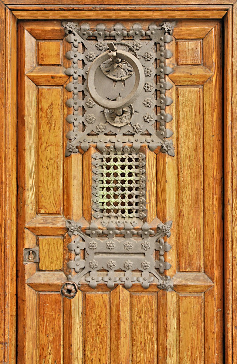 wood door with metal grates on top and window