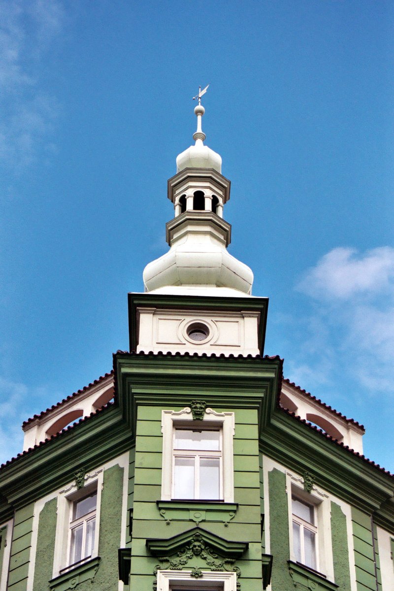 a green and white building with a steeple and a clock