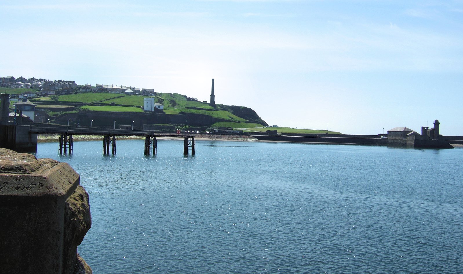 the view of a river with a bridge in the distance