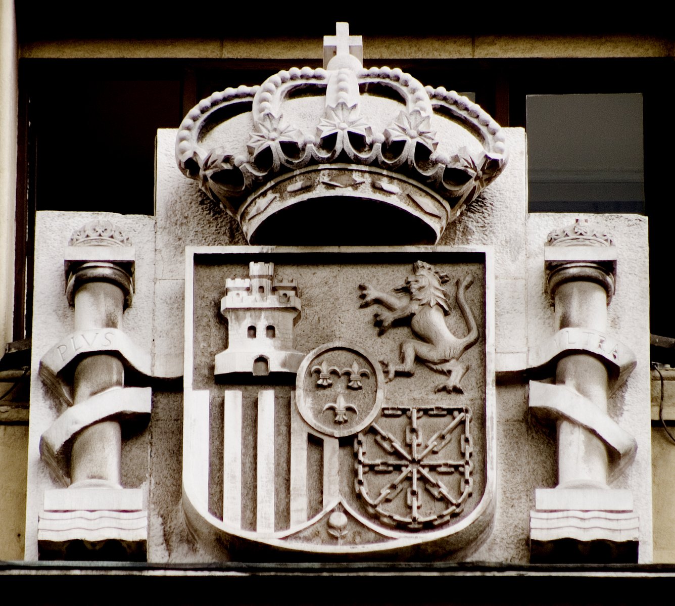 an coat of arms and two lions are embellished on the facade of a building