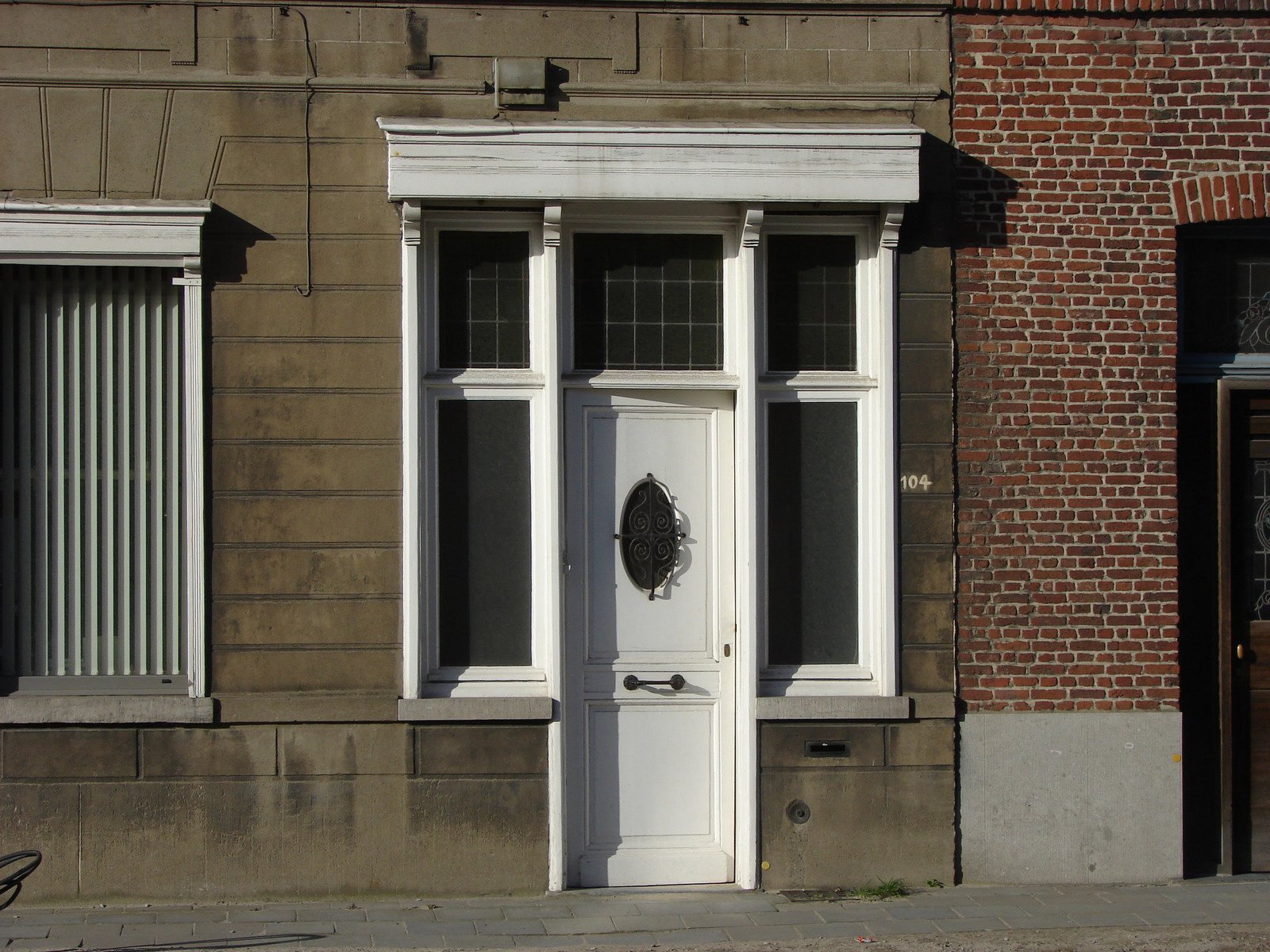 a white door and windows on a grey brick wall