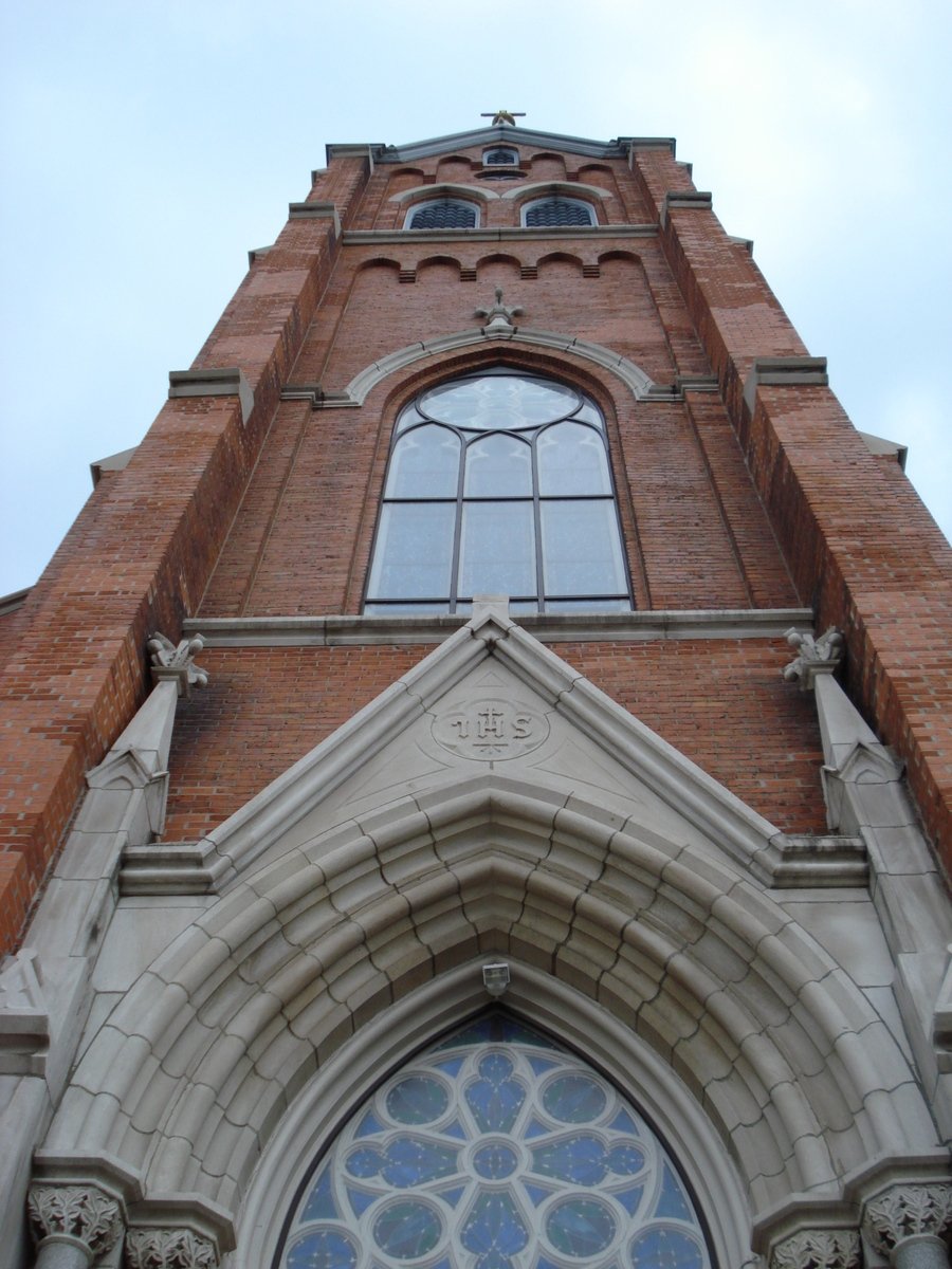 a tall brick church with a decorative window