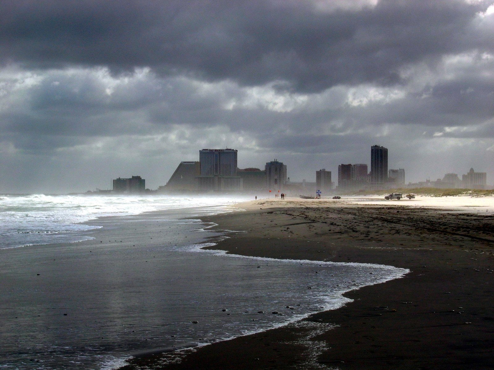 a beach in the middle of a storm filled sky