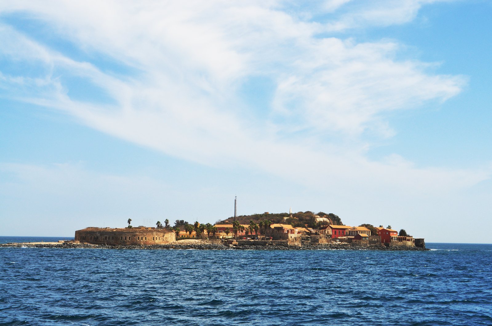 an island with buildings in the middle of it in a body of water